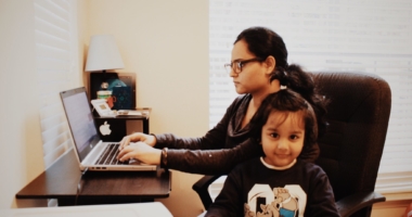 Busy mom working at desk with young daughter