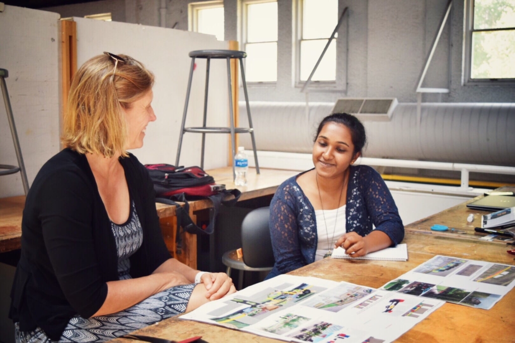 Teacher and student sitting at table in classroom