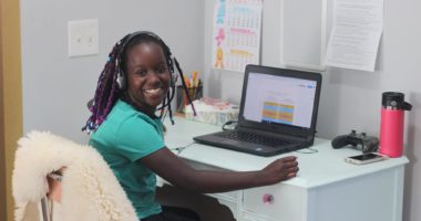 Female student sitting a desk and working on laptop