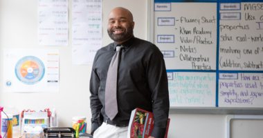 Male sixth-grade math teacher with textbook