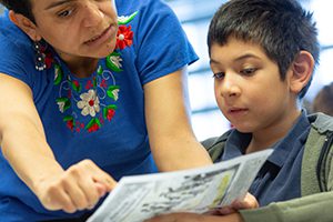 Female teacher instructing a student holding a paper