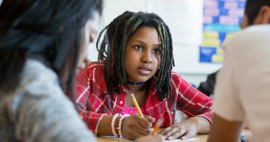 Sixth-grade math students collaborate on a group assignment